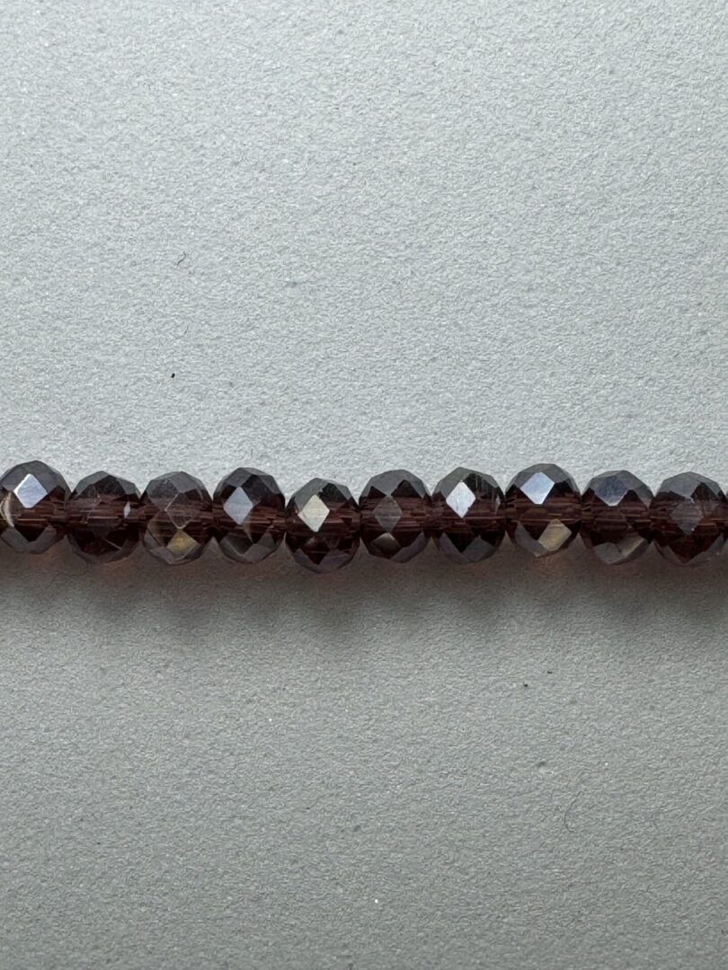 A row of dark brown glass beads.