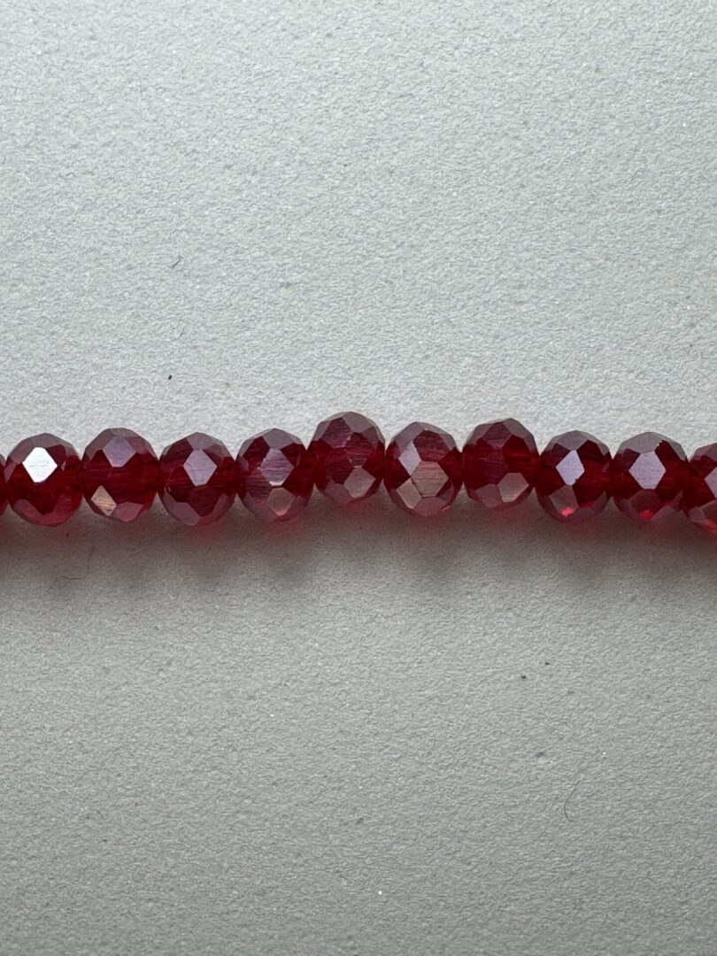 Row of red faceted glass beads.