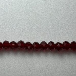 Red crystal beads on a white background.