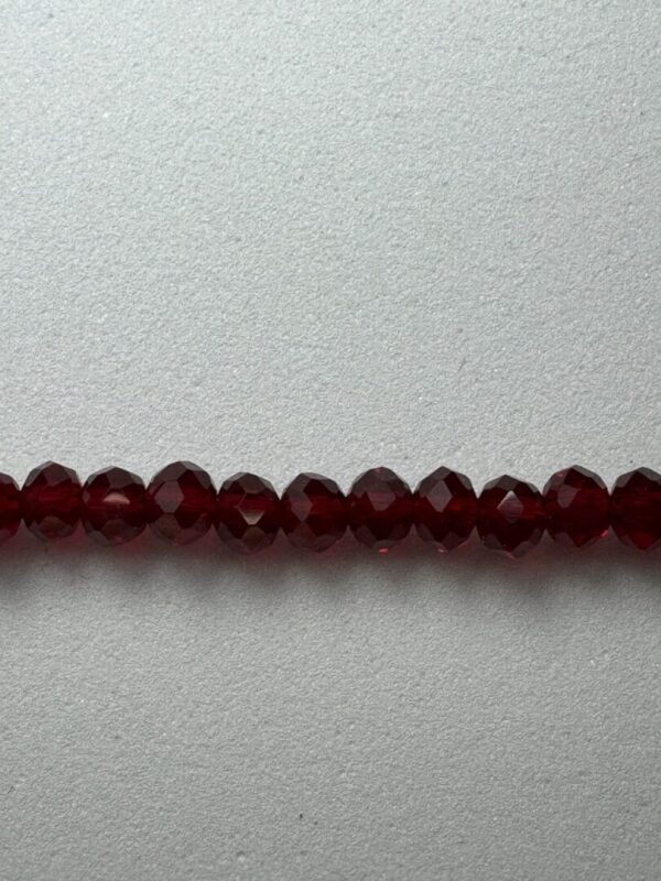 Red crystal beads on a white background.