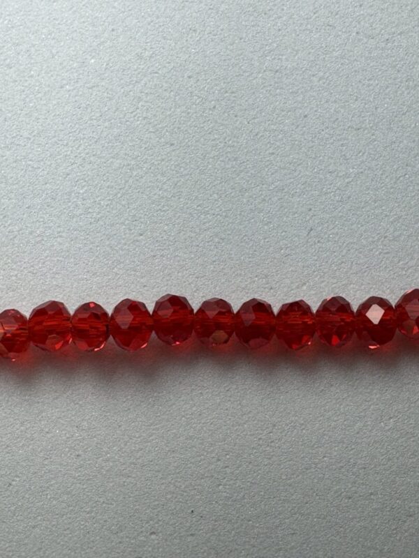 Red faceted glass beads on white background.