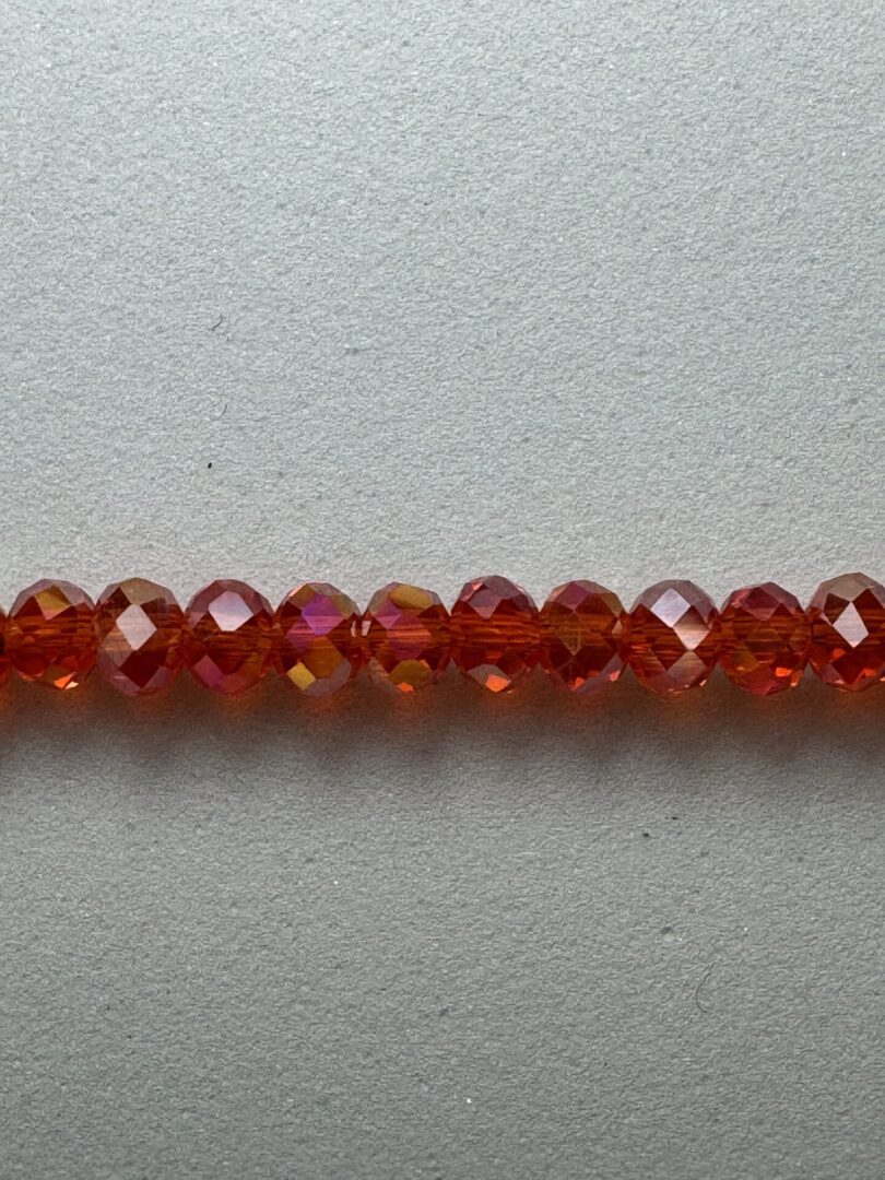 Row of red faceted glass beads.