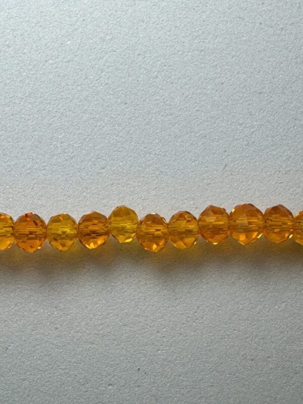 Row of amber faceted glass beads.