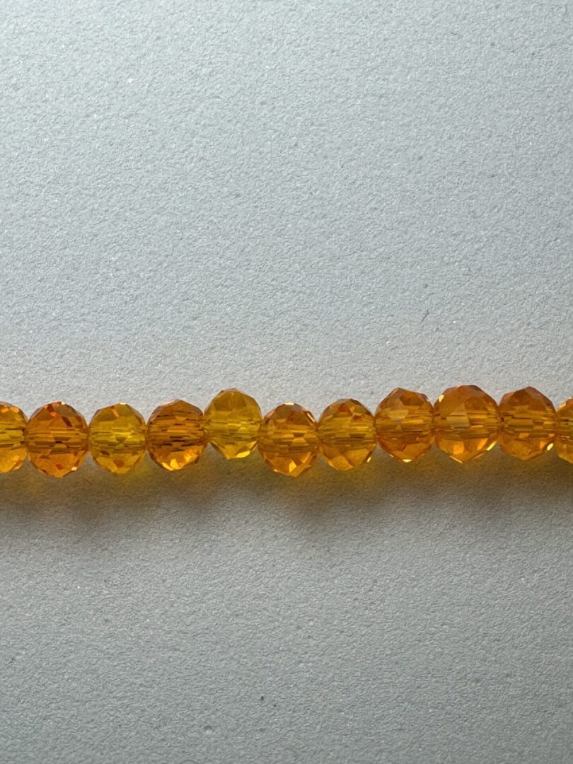 Row of amber faceted glass beads.