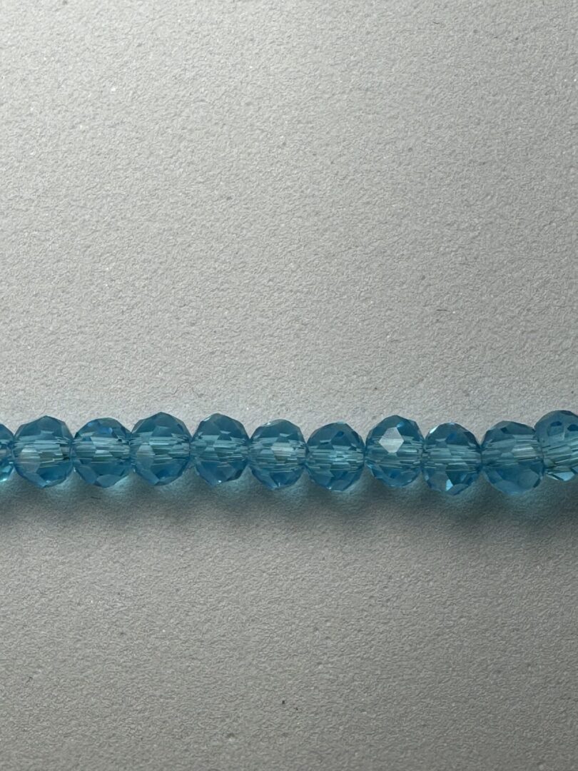 Row of blue crystal beads on white background.