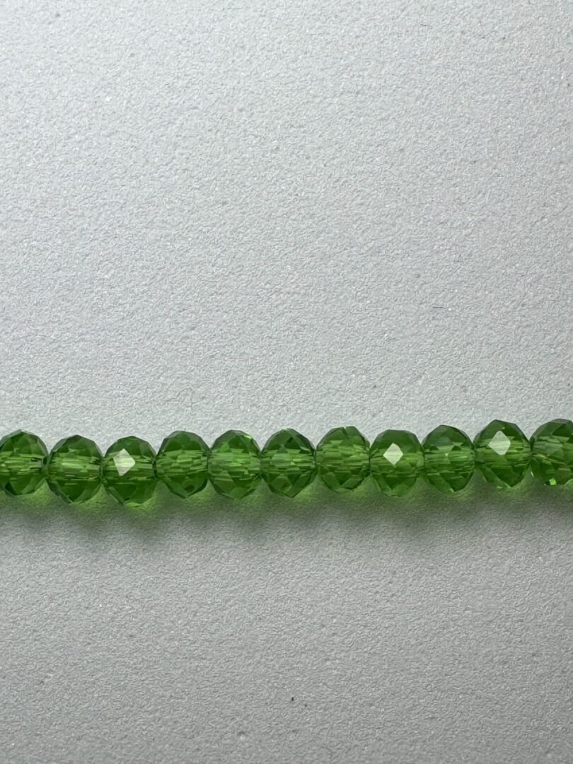 Row of green faceted glass beads.