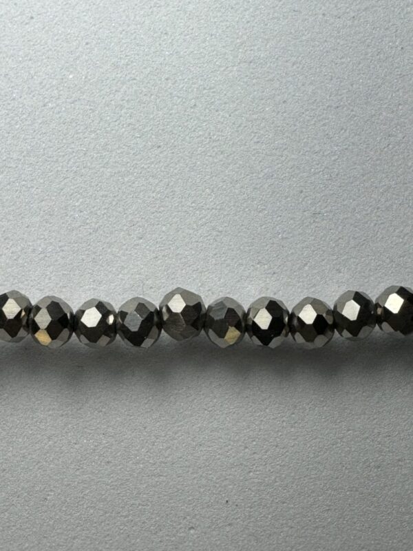 Row of black faceted glass beads.