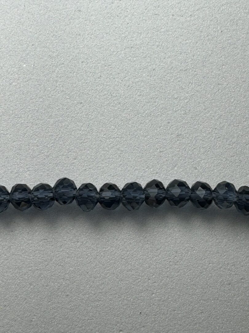 Black faceted glass beads on white background.