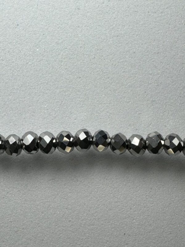 Black faceted beads on white background.