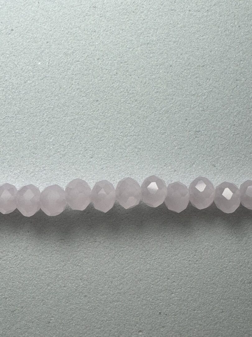 Row of pale pink faceted beads.