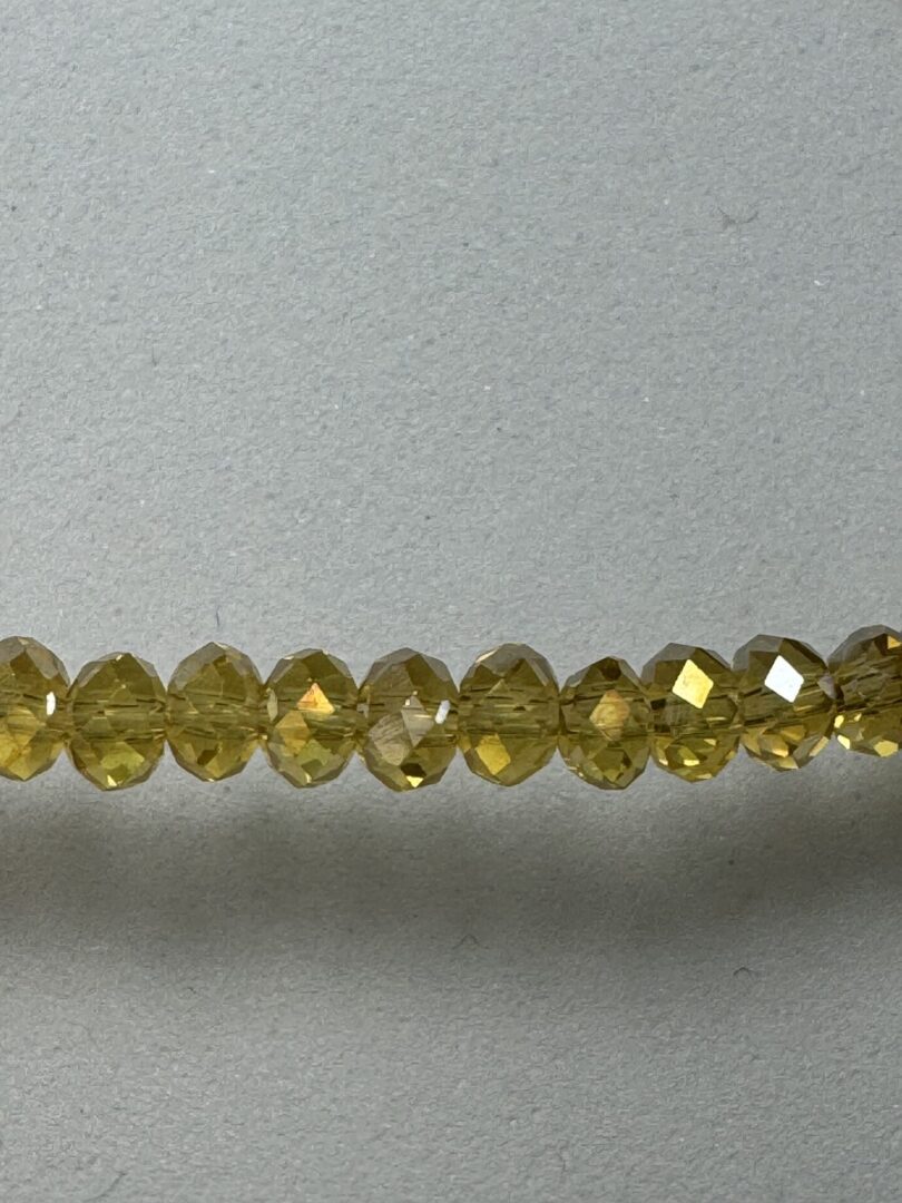 Row of shiny yellow glass beads.