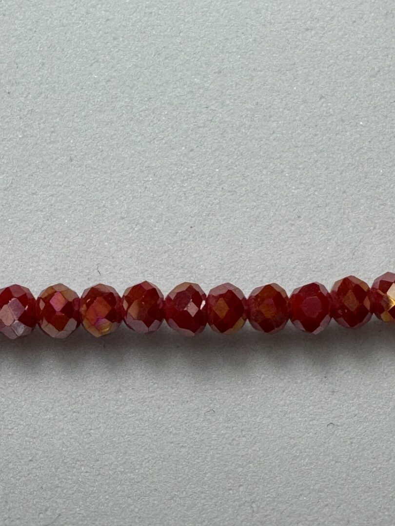 Red iridescent glass beads on white background.