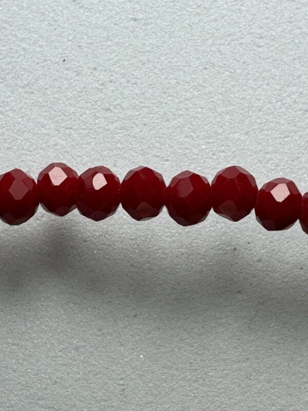 Row of red faceted glass beads.