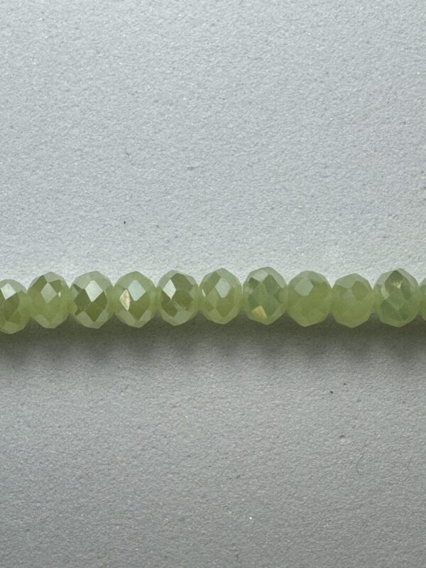 Green faceted gemstone beads on white background.