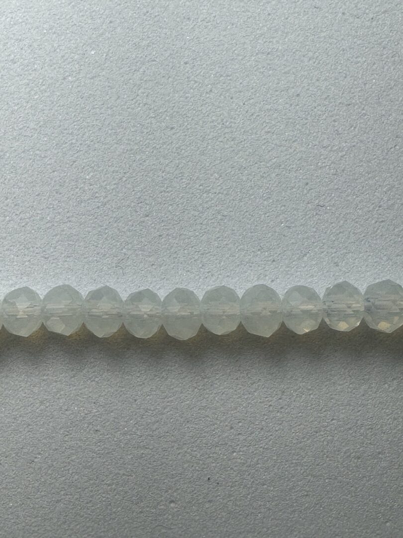 Row of white faceted glass beads.