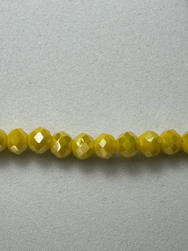 Row of yellow faceted glass beads.