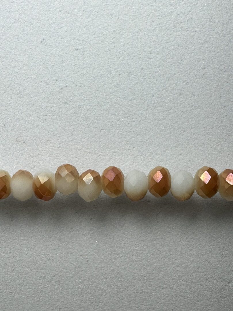 Row of iridescent white and brown beads.