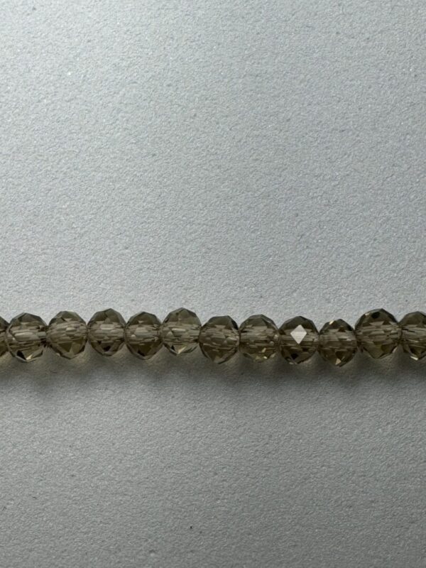 Row of smoky quartz beads on gray background.