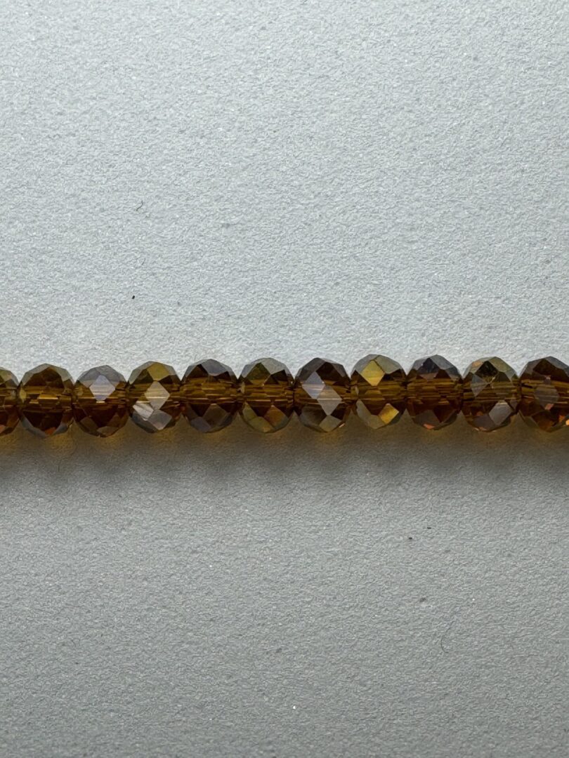 Row of brown faceted glass beads.