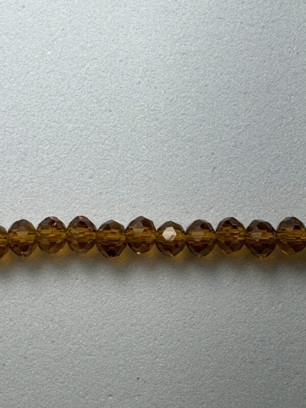 Row of brown crystal beads on grey background.