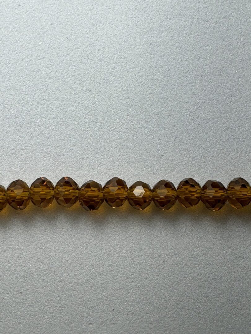 Row of brown crystal beads on grey background.