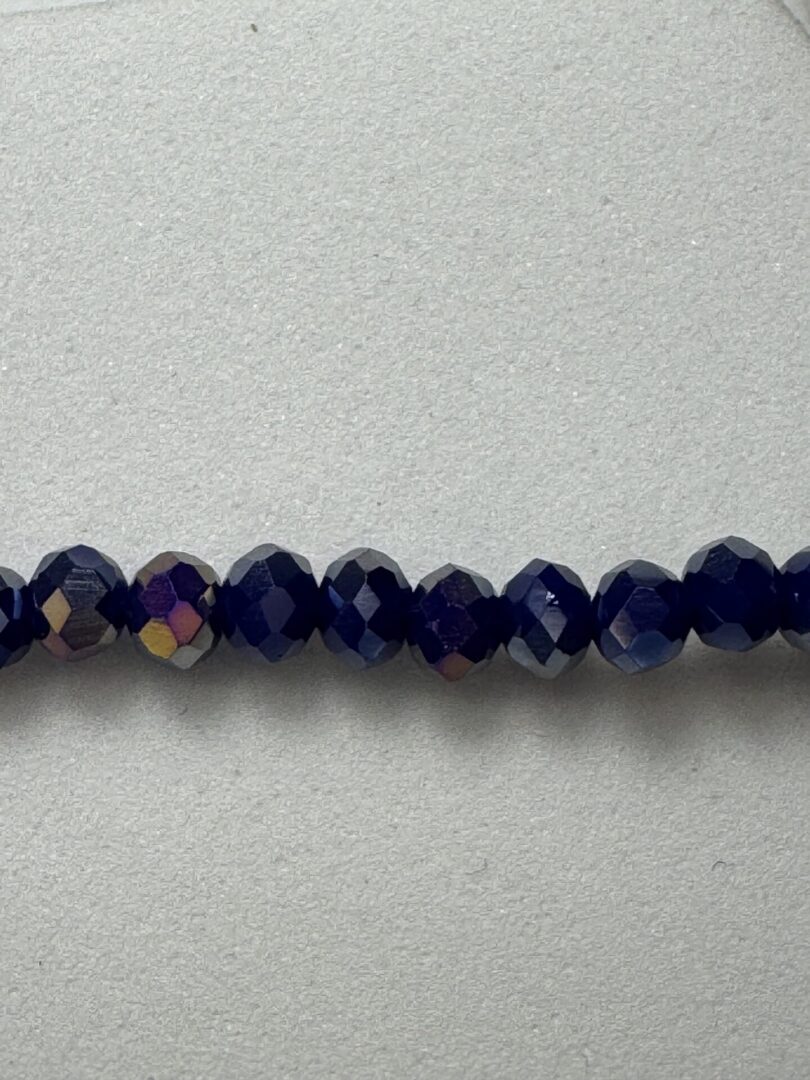 Row of iridescent dark blue beads.