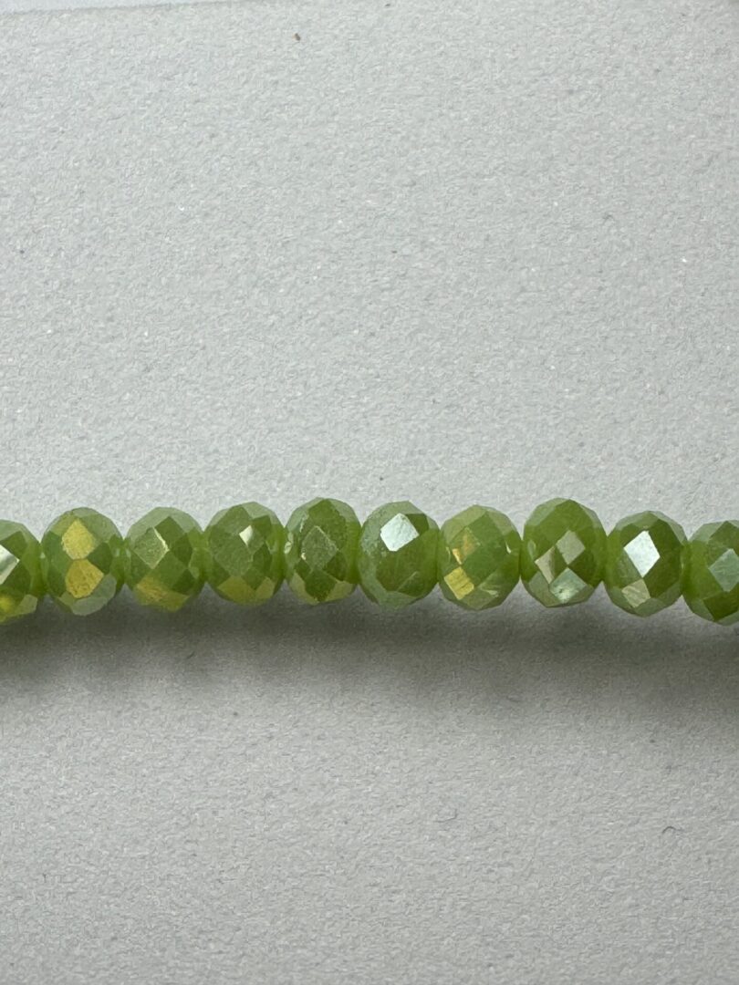 Row of green faceted glass beads.