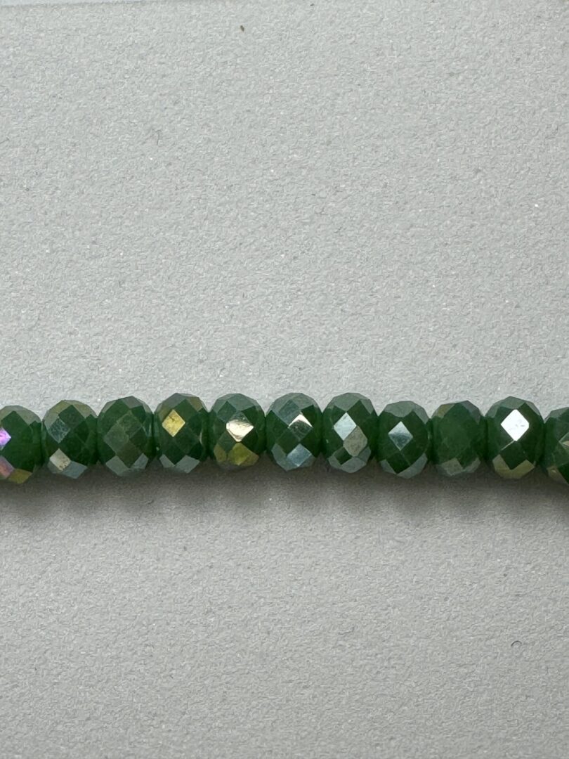 Row of green faceted glass beads.