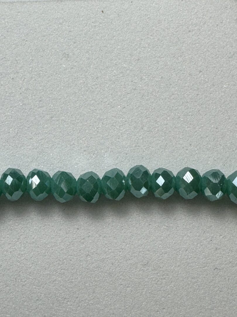 Row of green faceted glass beads.