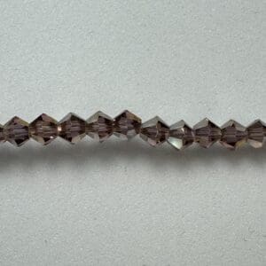 Here's an alt tag for the image: Mauve crystal beads strand.