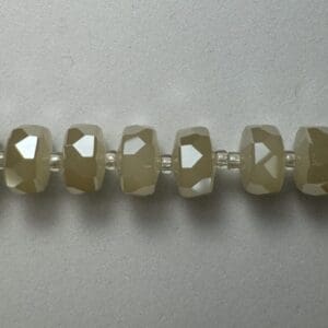 Beige faceted beads on string.