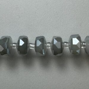 Grey faceted beads on string.