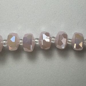 Light pink faceted beads on string.