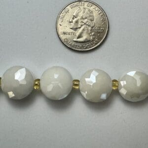 Off-white faceted beads with gold spacers.