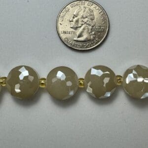 Beige faceted beads with gold spacers.