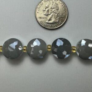 Grey faceted beads with gold spacers.