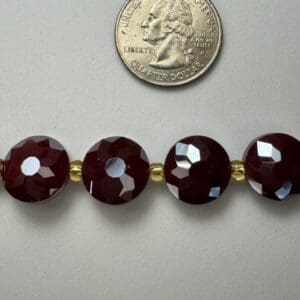 Dark red faceted beads with gold spacers.