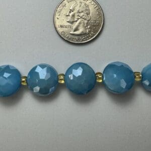 Teal gemstone necklace with gold beads.