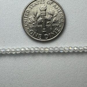 Clear glass beads next to a dime.