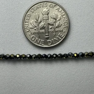 Here's an alt tag for the image: US dime next to black beads.