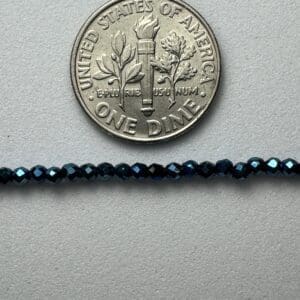 Dark blue glass beads with dime for scale.