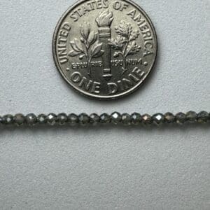 Gray glass beads next to dime.
