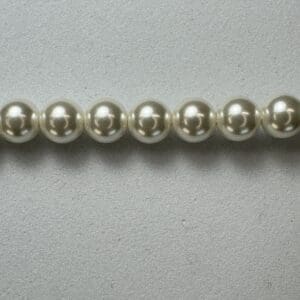 Cream pearl beads on grey background.
