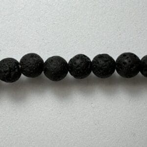 Black lava stone beads on white.