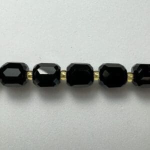 Black gemstone beads gold spacers necklace.