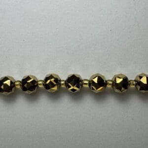Gold faceted beads on white background.