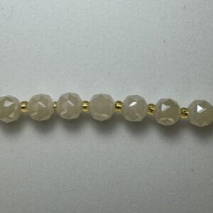 Beige faceted beads gold spacers necklace.