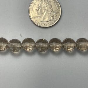 Smoky quartz beads with quarter for scale.
