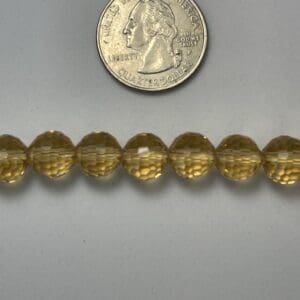 Yellow glass beads with quarter for scale.