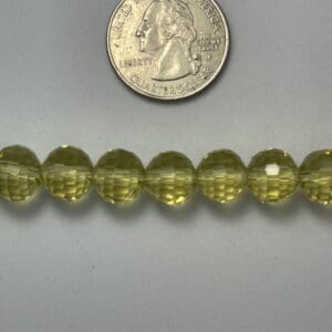 Yellow faceted beads with quarter for scale.